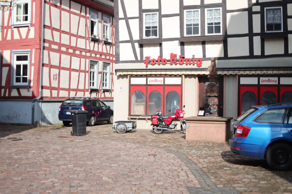 Eine rote Simson vor dem roten Schaufenster von "Foto König"