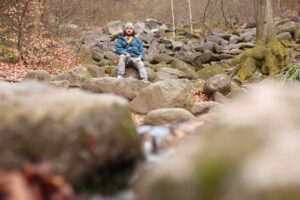 Konrad sitzt auf einem Felsen im Felsenmeer